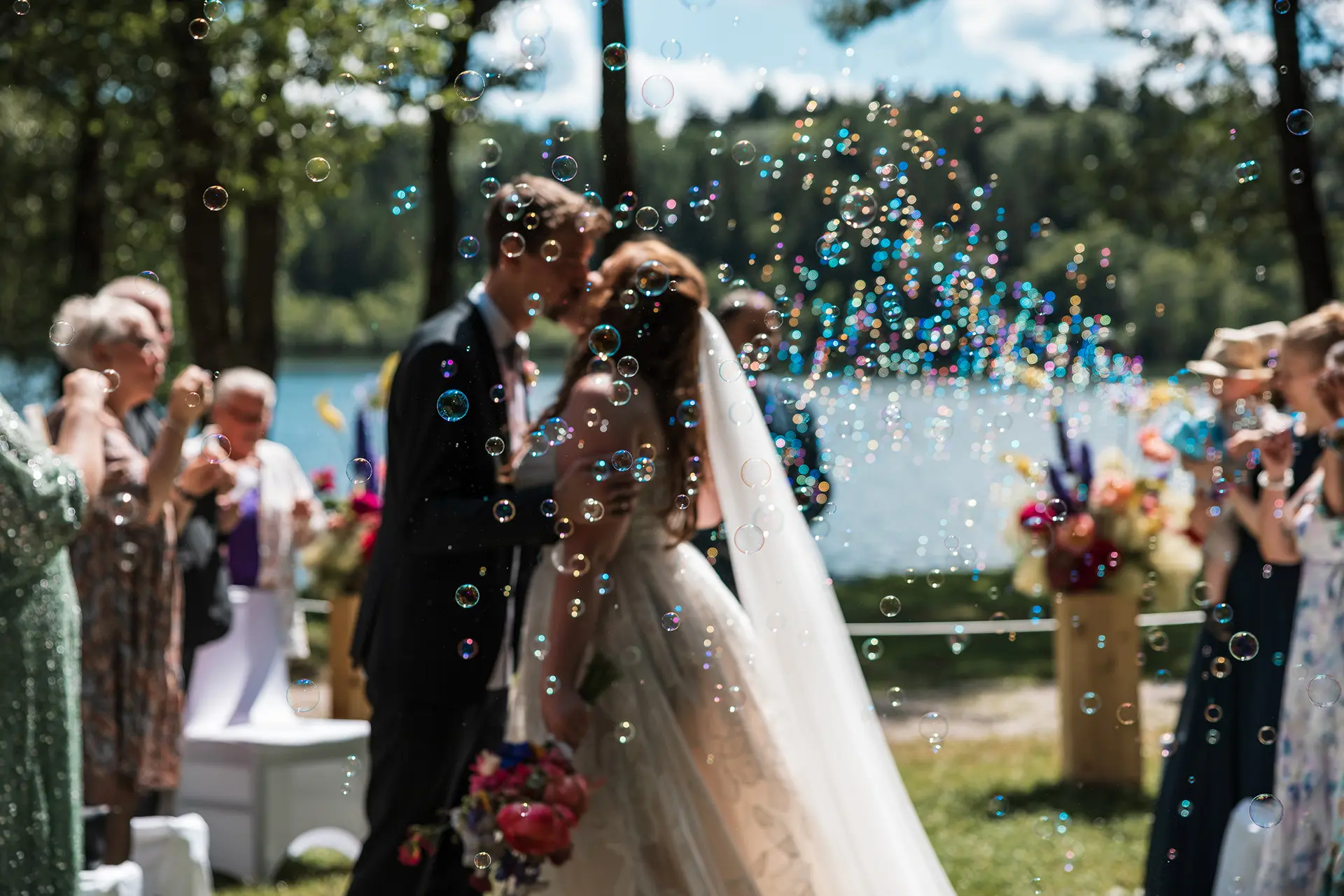 Brautpaar küsst sich mit Seifenblasen.
